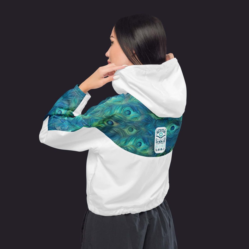 Femme portant le coupe-vent Reliks, vue arrière avec motifs de plumes de paon.